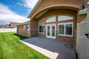 Side view of property featuring a patio and a fully fenced yard