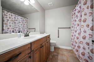 Main hall Bathroom featuring vanity, toilet, and tile patterned flooring