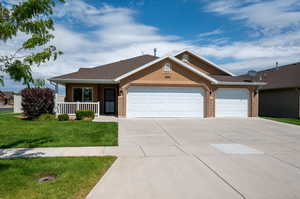 View of front of property with a front yard and a garage