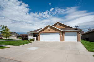 Patio home with a corner, fully landscaped front yard and a 3 car garage