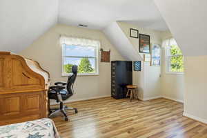 Office with light hardwood / wood-style flooring and vaulted ceiling