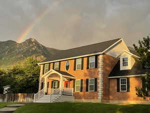 Colonial-style house featuring a front yard and a mountain view