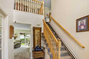 Stairway with carpet flooring and a high ceiling