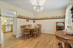 Dining area featuring light hardwood / wood-style flooring and an inviting chandelier