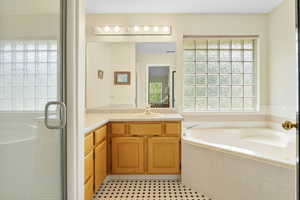 Bathroom with shower with separate bathtub, vanity, and tile patterned flooring