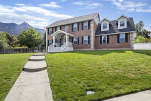 Colonial house with a front lawn and a mountain view