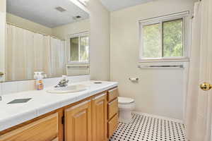 Bathroom with vanity, toilet, and tile patterned flooring