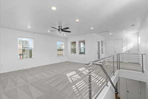 Empty room featuring ceiling fan and light carpet