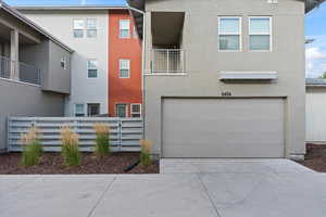 View of front of property featuring a balcony and a garage