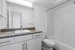 Full bathroom featuring tub / shower combination, a textured ceiling, toilet, and vanity