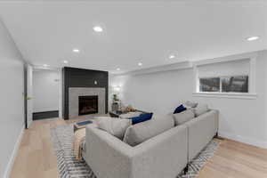 Living room with light hardwood / wood-style flooring and a tile fireplace