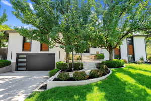 View of front facade featuring a front yard and a garage