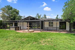 Rear view of property featuring a pergola, a patio, and a yard