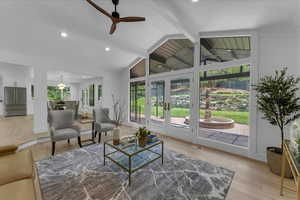 Living room with ceiling fan, light hardwood / wood-style flooring, french doors, and lofted ceiling with beams