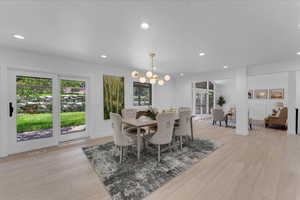 Dining space with an inviting chandelier and light hardwood / wood-style floors