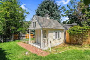 Rear view of property with a yard and an outbuilding