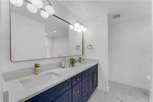 Bathroom with dual bowl vanity and tile patterned floors