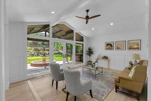 Living room featuring ceiling fan, french doors, lofted ceiling with beams, and light wood-type flooring