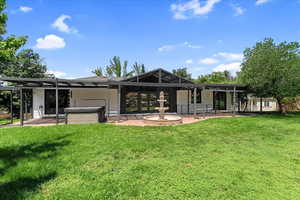 Rear view of house featuring a patio area and a lawn