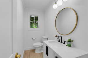 Bathroom with vanity, toilet, hardwood / wood-style flooring, and crown molding