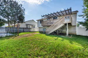 View of yard with deck and a pergola