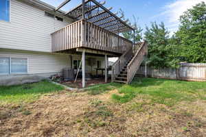 Back of house with a lawn, central AC unit, and a deck