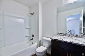 Full bathroom featuring vanity, shower / tub combination, and toilet