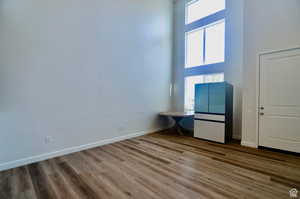 Unfurnished living room featuring a towering ceiling and hardwood / wood-style floors