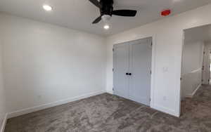 Unfurnished bedroom featuring ceiling fan, carpet floors, and a closet