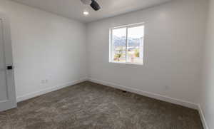 Carpeted empty room with ceiling fan