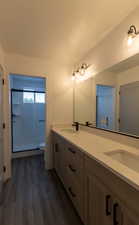 Bathroom featuring vanity, a textured ceiling, wood-type flooring, toilet, and a shower with shower door
