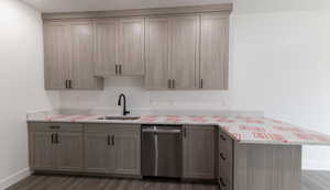 Kitchen with kitchen peninsula, stainless steel dishwasher, dark wood-type flooring, sink, and gray cabinets