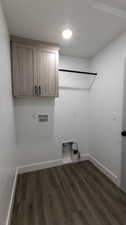 Clothes washing area featuring gas dryer hookup, cabinets, washer hookup, hookup for an electric dryer, and dark hardwood / wood-style flooring