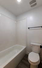 Bathroom with hardwood / wood-style flooring and toilet