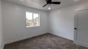 Empty room featuring ceiling fan and carpet floors