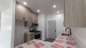 Kitchen with sink, stainless steel appliances, and light brown cabinetry