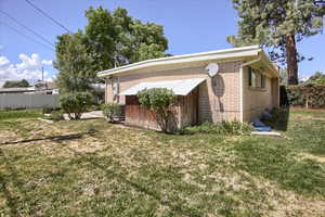 View of side of home featuring a lawn