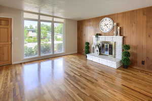 Unfurnished living room featuring wood walls and light hardwood / wood-style flooring