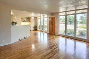 Unfurnished living room with light wood-type flooring and built in features