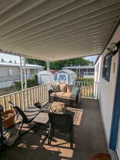 View of patio with an outdoor hangout area and a storage shed