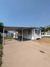 Manufactured / mobile home featuring a shed and a carport