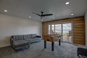 Rec room with a ceiling fan, carpet floors, recessed lighting, and wood walls