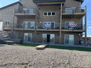 Back of house with a balcony, a patio area, and outdoor lounge area