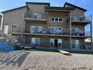 Rear view of house featuring a balcony, a patio, and an outdoor living space