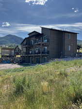 Rear view of property featuring a balcony and a mountain view