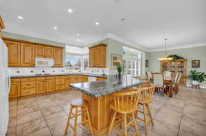 Kitchen featuring kitchen peninsula, white appliances, tasteful backsplash, and a healthy amount of sunlight