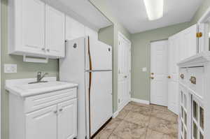 Laundry area featuring light tile patterned floors and sink