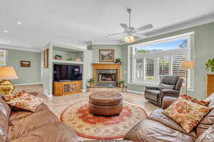 Tiled living room with ceiling fan and ornamental molding