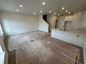 Kitchen with white cabinets, sink, and an island with sink