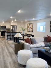 Living room with a textured ceiling and light hardwood / wood-style floors